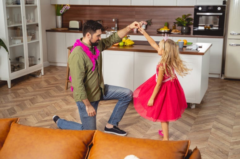 Smiling father dancing with his daughter 