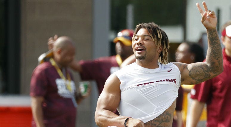 Redskins RB Derrius Guice waves to fans at training camp.