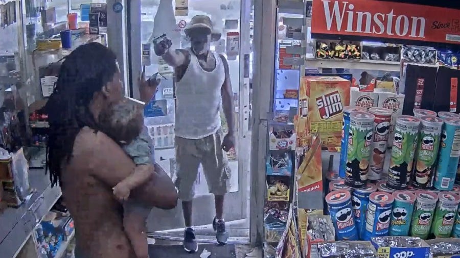 WATCH: Suspect points gun at father holding his 7-month-old son at Detroit gas station