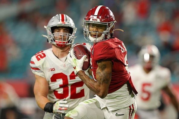 Devonta Smith looks for room to run after making a catch.