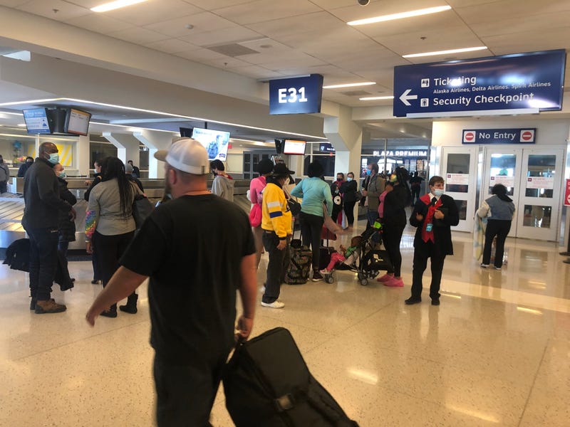 Travelers wait for their luggage at Dallas-Fort Worth International Airport on Thursday, Dec. 23, 2021.