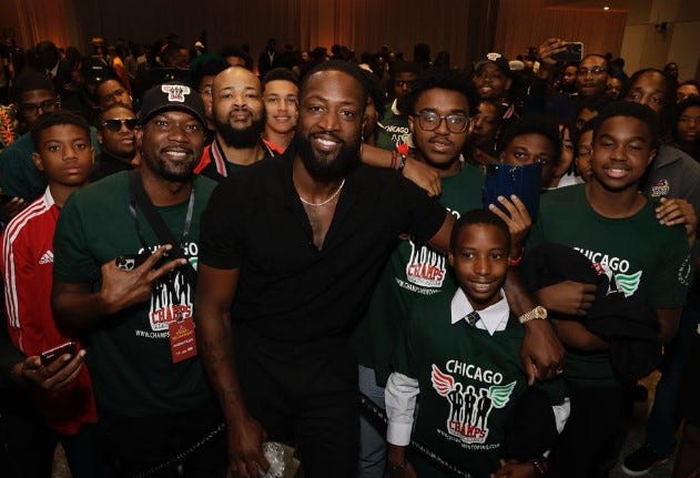 Dwyane Wade surrounded by CHAMPS Mentoring kids