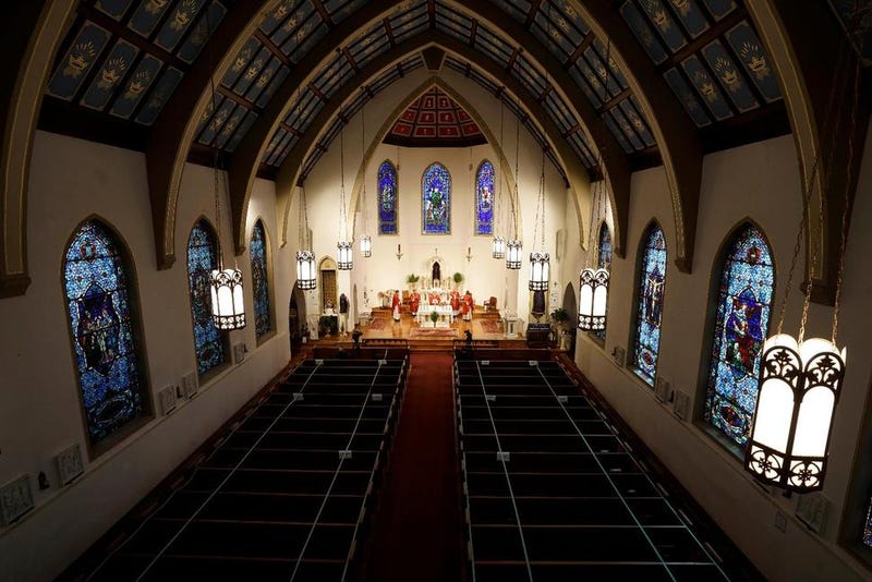 FILE - In this Sunday, April 5, 2020, file photo, The Most Rev. Peter Jugis, Bishop of Charlotte, conducts Palm Sunday services inside the empty St. Patrick Cathedral in Charlotte, N.C. Due to the coronavirus pandemic, the service was closed to the public but was live streamed across western North Carolina. Catholic entities in the Charlotte Diocese received more than $8 million in paycheck program aid.