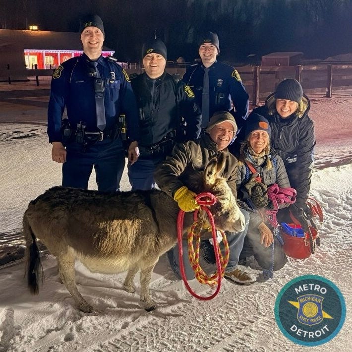 Dolly Parton the donkey poses with her owners and MSP troopers