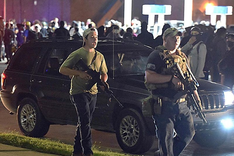 In this Aug. 25, 2020, file photo, Kyle Rittenhouse, left, with backwards cap, walks along Sheridan Road in Kenosha, Wis., with another armed civilian. Rittenhouse was among a number of armed white men who converged on the city this summer, claiming to protect property owners from arson and theft, one example of political or social unrest that has caused increased anxiety levels among African Americans.