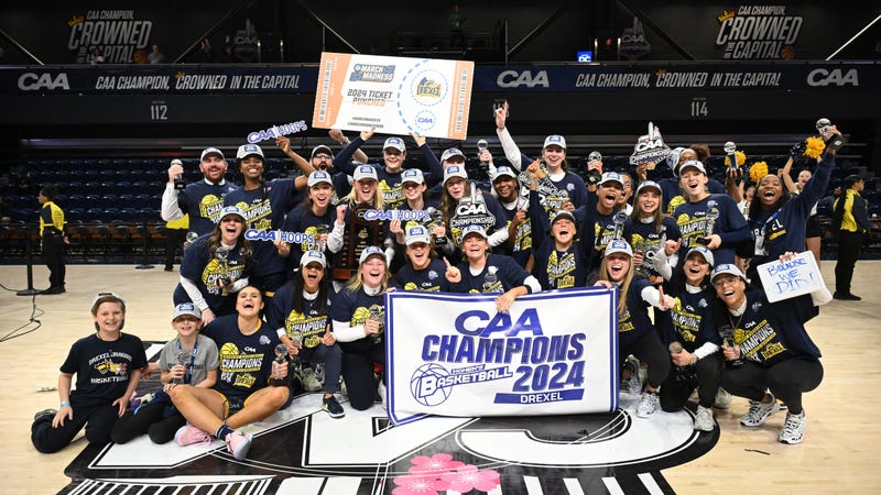Drexel University's women's basketball team on the court holding a "CAA Champions" banner.