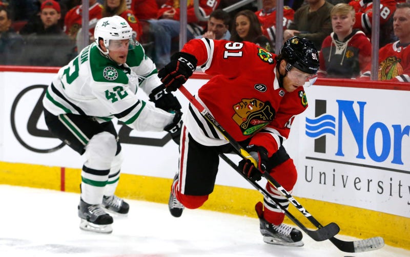 Blackhawks center Drake Caggiula (91) controls the puck in front of Stars defenseman Taylor Fedun (42).