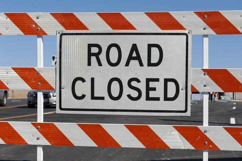 Worn Road Closed Sign in front of street being repaired