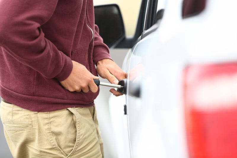 Stock image of someone breaking into a car.