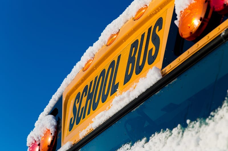 The front of a school bus after a fresh winter snowfall.