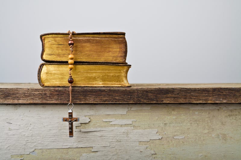 Rosary beads and books of Catholic Church liturgy