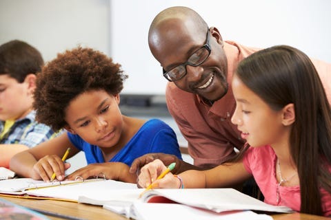 Teacher helping students with school work.