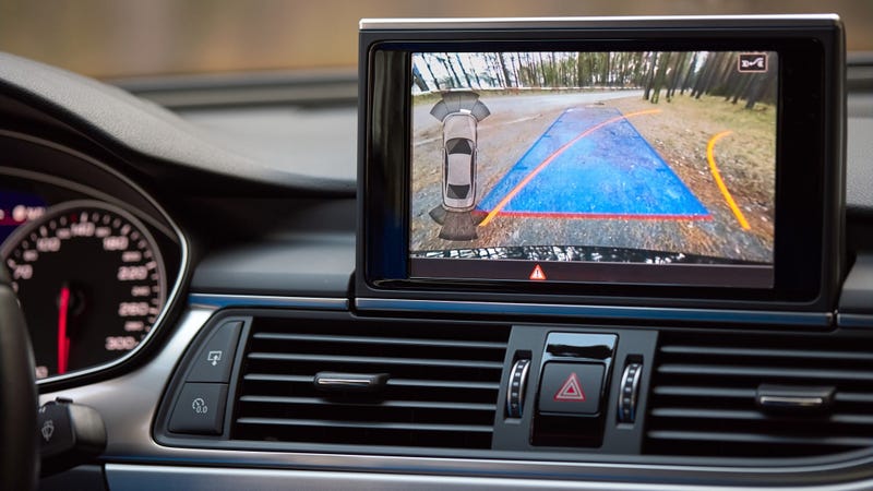 Interior of premium car with rearview camera dynamic trajectory turning lines and parking assistant steering wheel turned right. Driver assistance parking system. Help assist options of luxury car.