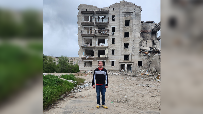 Joe Dubyk in front of a ruined building in Ukraine