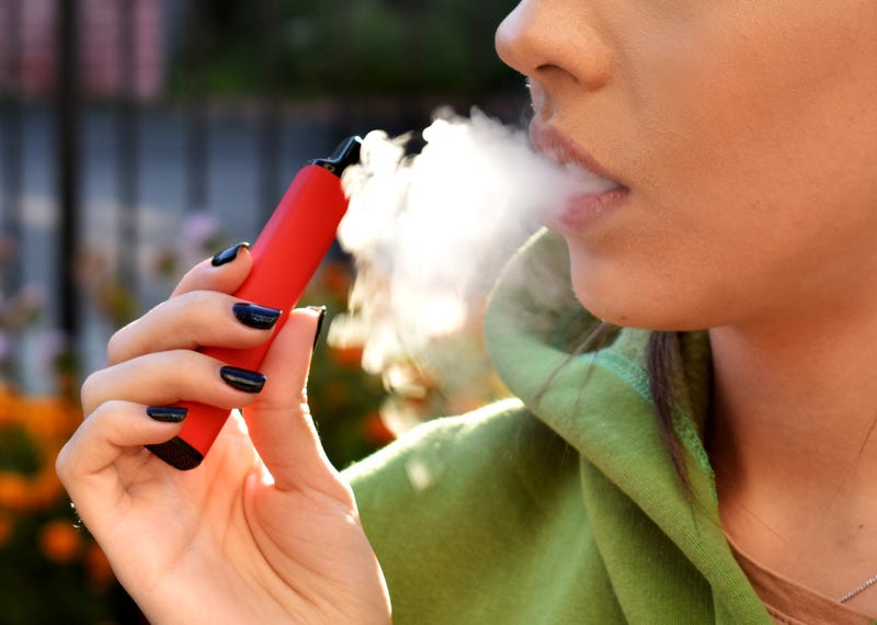 woman puffing on e-cigarette