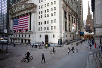 FILE- In this March 18, 2020, file photo a few people walk on Wall Street in front of the New York Stock Exchange in New York. (AP Photo/Mark Lennihan, File)