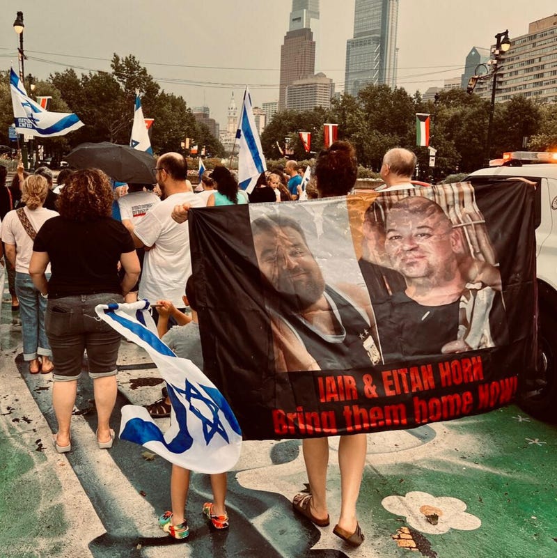 Noga Senderowitsch, with her 5-year-old son Max, carries a banner bearing Iair and Eitan Horn’s images at a Bring Them Home rally in Philadelphia earlier this year.