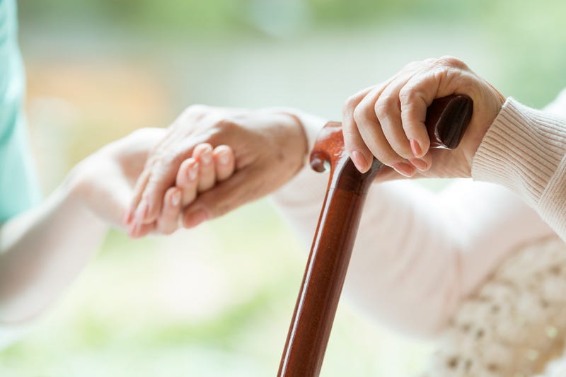 Elder person supported on wooden stick