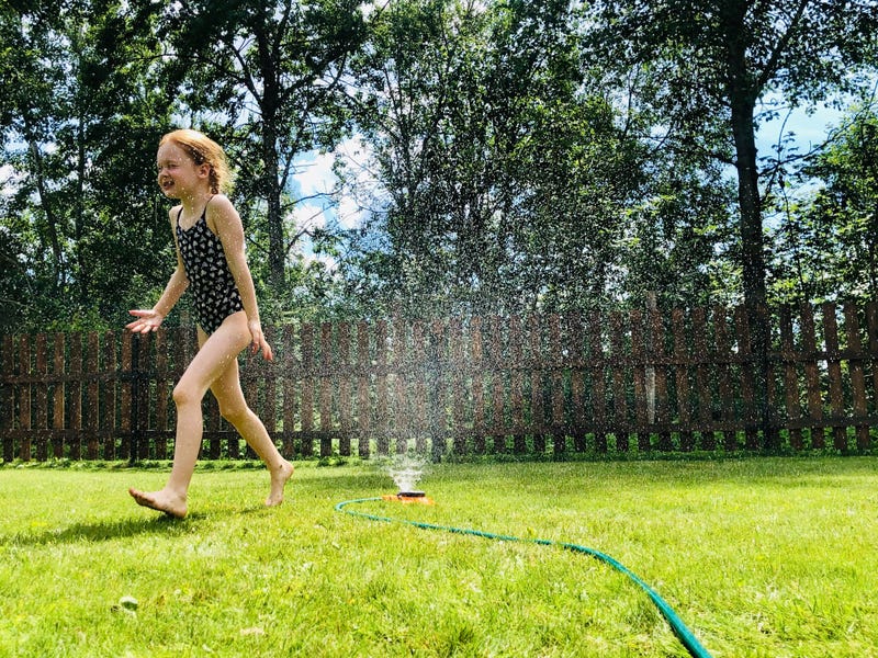 little girl playing in the sun outside 