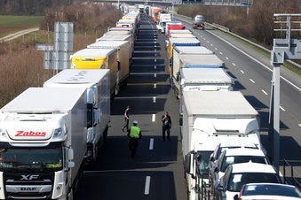 Trucks stand on the highway close to the border between Austria and Hungary near Bruck an der Leitha, Austria, Wednesday, March 18, 2020. (AP Photo/Ronald Zak)