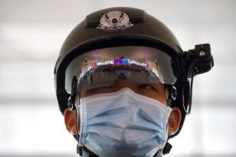 A police officer wearing a face mask to protect against the spread of new coronavirus stands guard at Wuhan Tianhe International Airport in Wuhan in central China's Hubei Province. (AP Photo/Ng Han Guan)