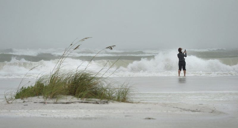 Erika Lane takes photos of the surf at Lido Public Beach in Sarasota, Fla. on Wednesday, Nov. 11, 2020 as Hurricane Eta passes to the west in the Gulf of Mexico.