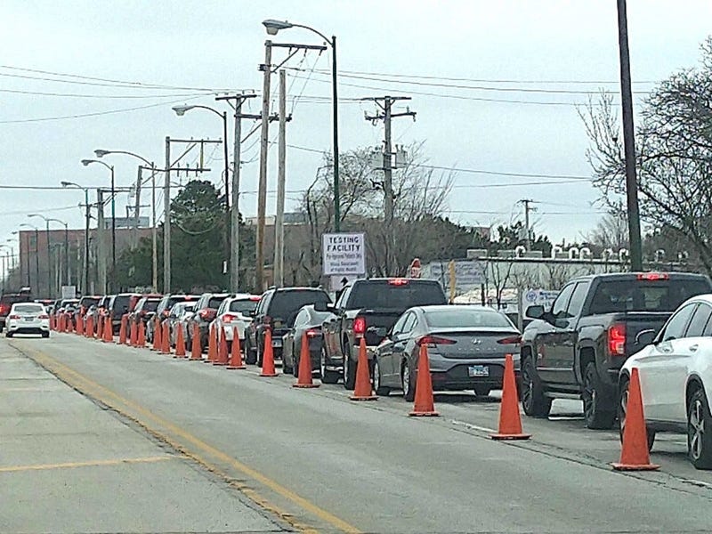 Cars wait outside a COVID-19 test site on the Northwest Side on March 23, 2020. 