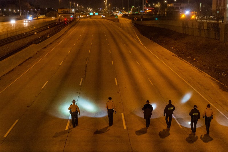 Illinois State Police walk in formation, Friday morning, on the inbound I-94 Expressway near 79th Street, looking for evidence of the shooting that left one woman wounded.