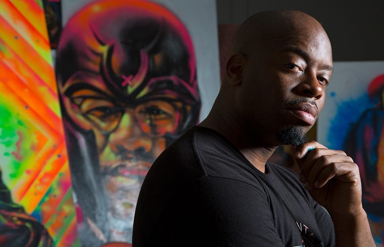 Fabian Williams poses in front of one of his paintings