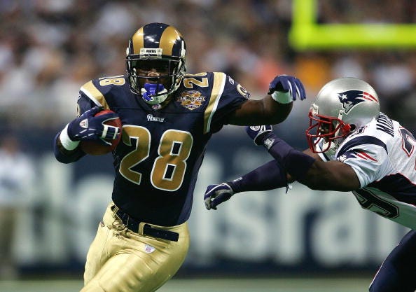 Marshall Faulk evades a tackle during a Rams game.