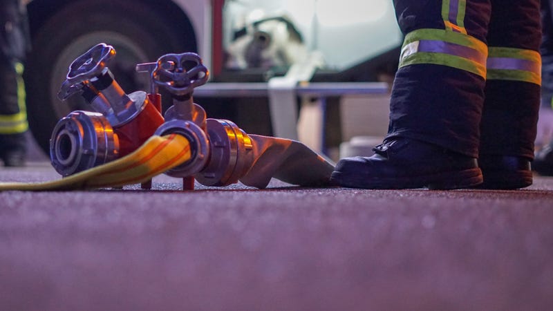Low angle picture of a firefighter standing on street at night - stock photo