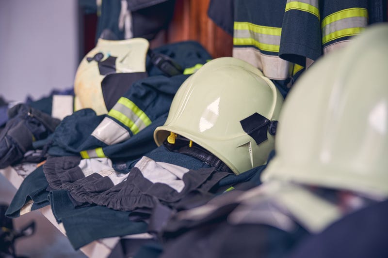 Firefighter suits and helmets hanging at fire station