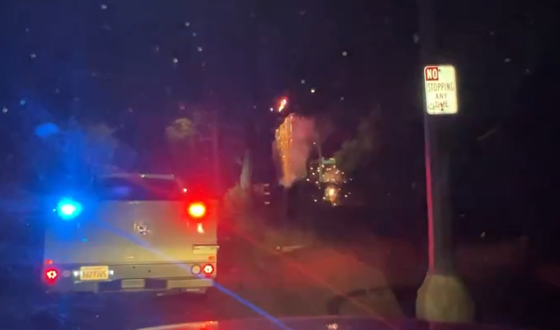 fireworks go off with police lights flashing