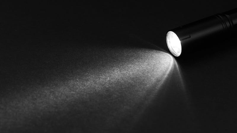 Flashlight and beam of light on a dark background