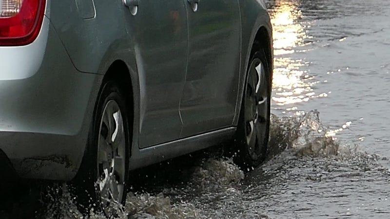 Cars crossing flooded urban street