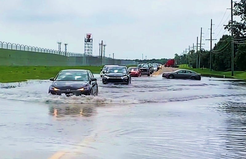 Some drivers make it through the flood waters, and some do not, on Vining Road on the way to Detroit Metro Airport.