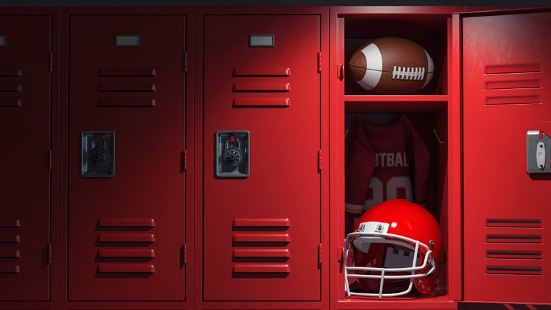 Football locker room with equipment, ball and helmet