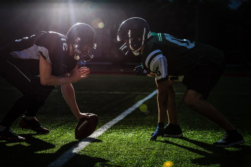 Football players on modern field at night