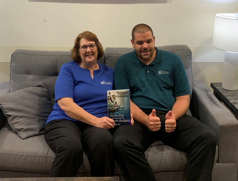 Sandy Hartranft and her son Ben Hartranft pose with Carol's new book, "Swinging from the Chandelier: Finding Joy in the Journey Through Autism".