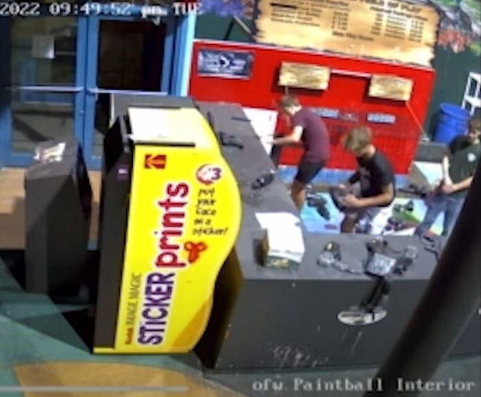 Surveillance video of a paintball shop while three individuals rummage through supplies