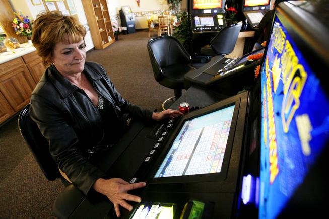 Woman playing a table top video poker machine