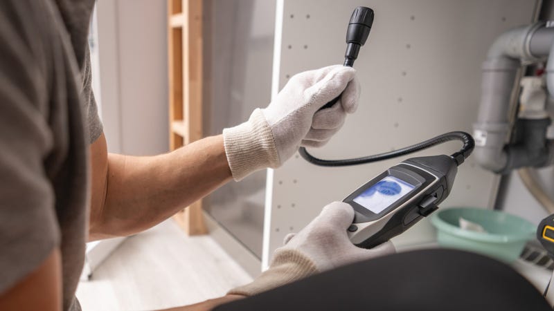 Technician with gas detector in his hands - stock photo