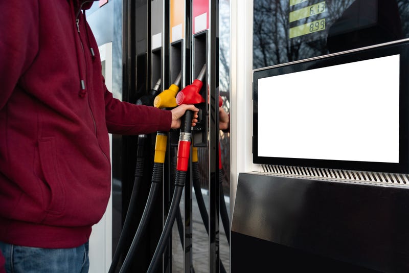 A person stands at a gas pump. Gas prices are at record highs, and some legislators are discussing a gas tax holiday.