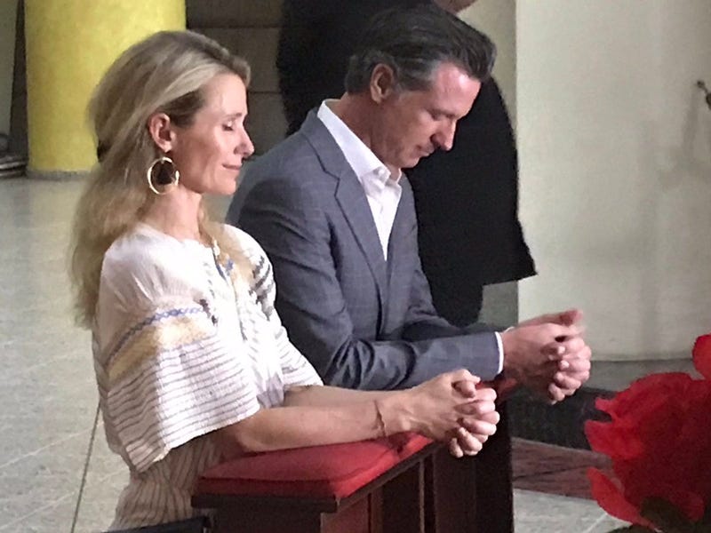 Governor Newsom and First Partner Jennifer Siebel Newsom pray at the tomb of Oscar Romero in San Salvador