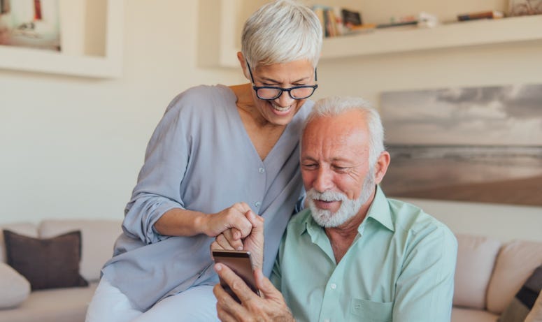 Happy couple sees a positive message on their mobile device