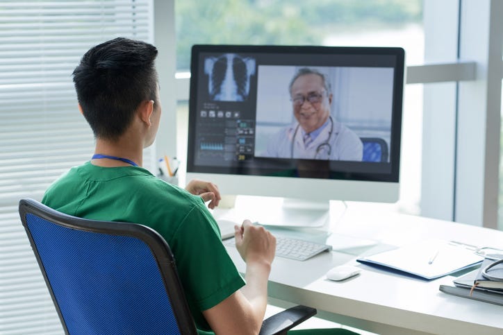 Two doctors communicating through a computer.
