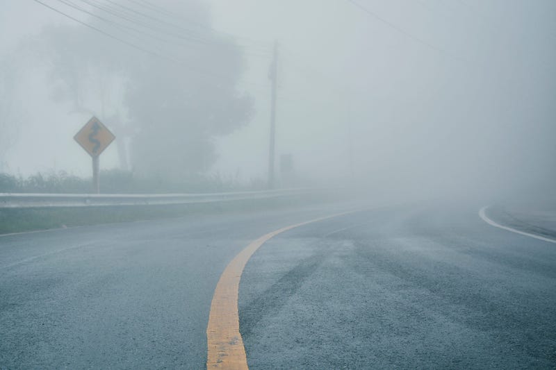 foggy rural asphalt highway perspective with white line, misty road, Road with traffic and heavy fog, bad weather driving - stock photo