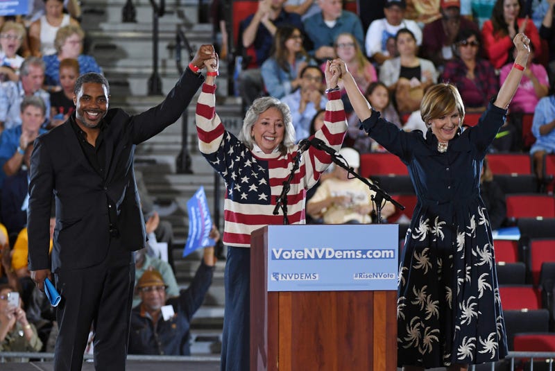 Democratic candidate for Nevada's 4th House District Steven Horsford, U.S. Rep. Dina Titus (D-NV) and Democratic candidate for Nevada's 3rd House District Susie Lee hold hands and raise their arms after speaking during a get-out-the-vote rally