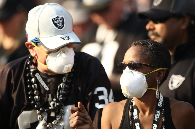 Fans wear face masks in the stands during the NFL game between the Oakland Raiders and the Los Angeles Chargers at Oakland-Alameda County Coliseum on November 11, 2018 in Oakland, California.