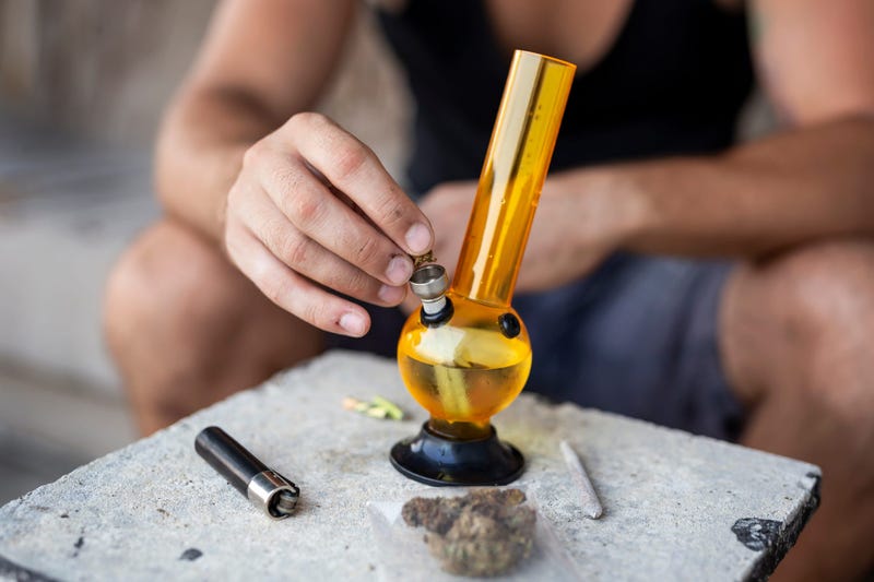 Man preparing to smoke marijuana with a water pipe